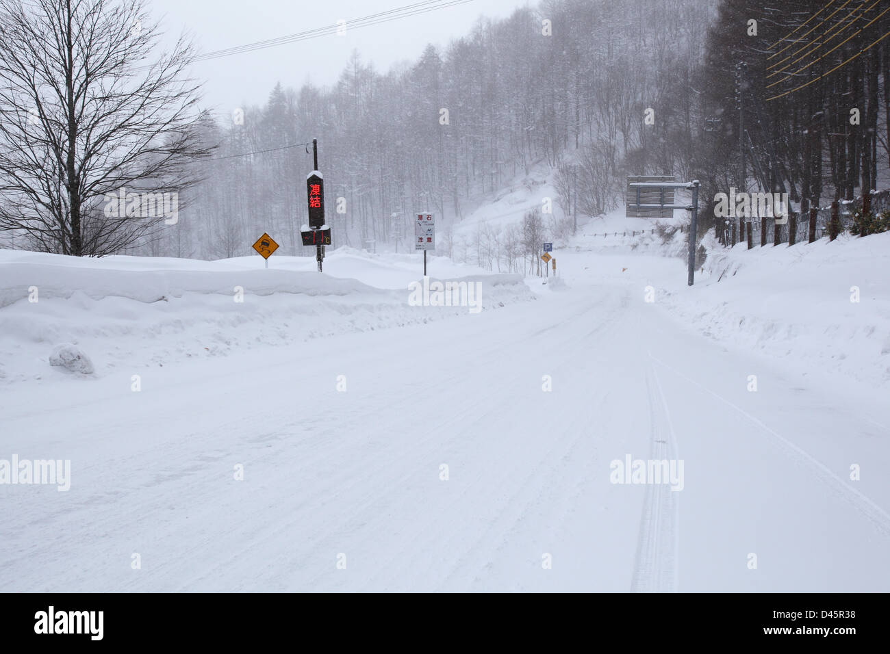 Attention gel signe sur une route couverte de neige Banque D'Images