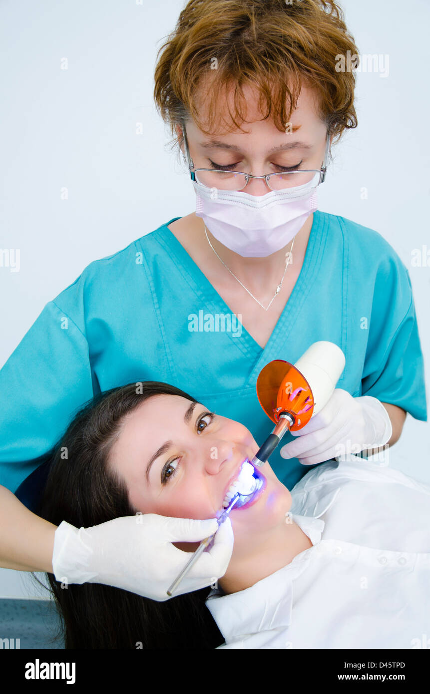 Utilisation professionnelle d'outils de dentiste chirurgien patient lampe UV Banque D'Images
