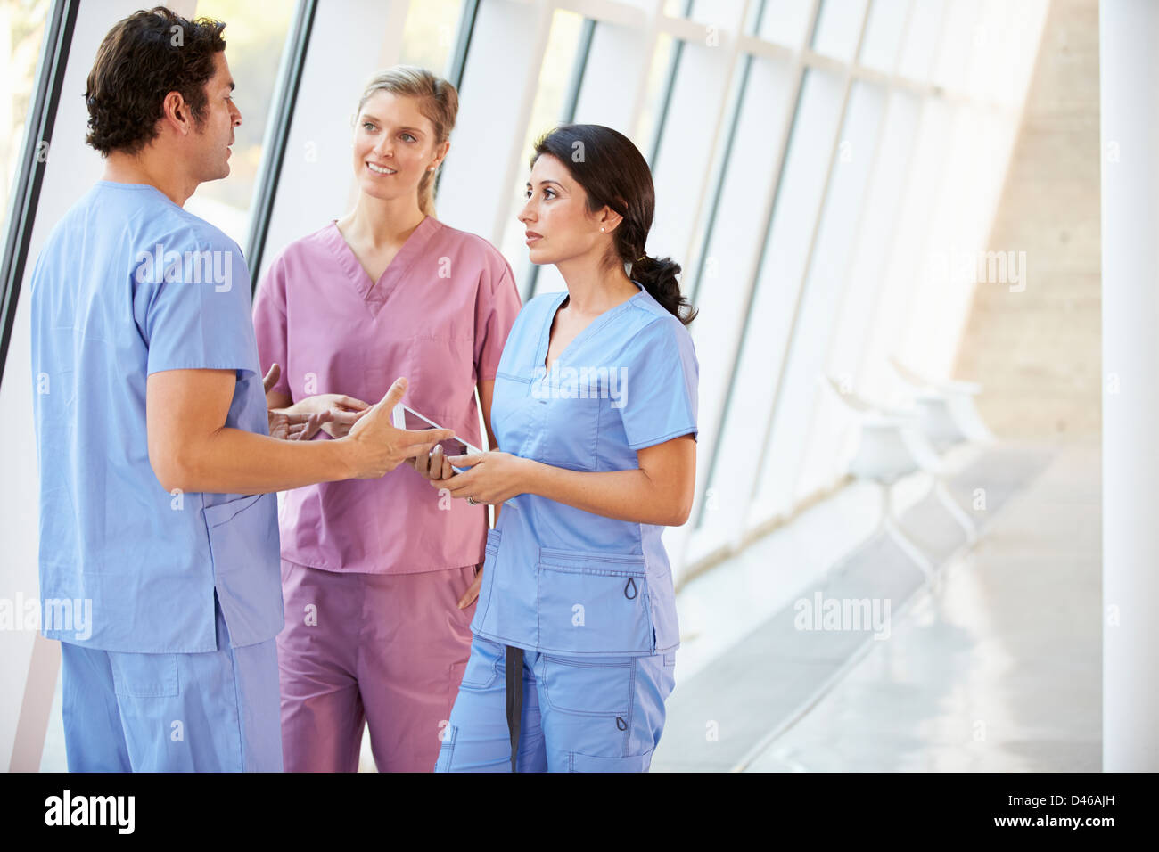 Le personnel médical parler in Hospital Corridor with Digital Tablet Banque D'Images
