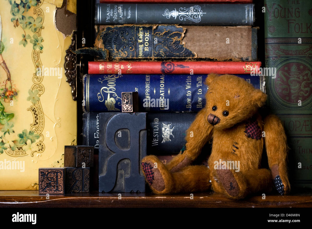 Une bibliothèque dotée d''une vie encore ours articulé, antique lettre Appuyez sur les lettres, les vieux livres et un album photo de l'époque victorienne. Banque D'Images