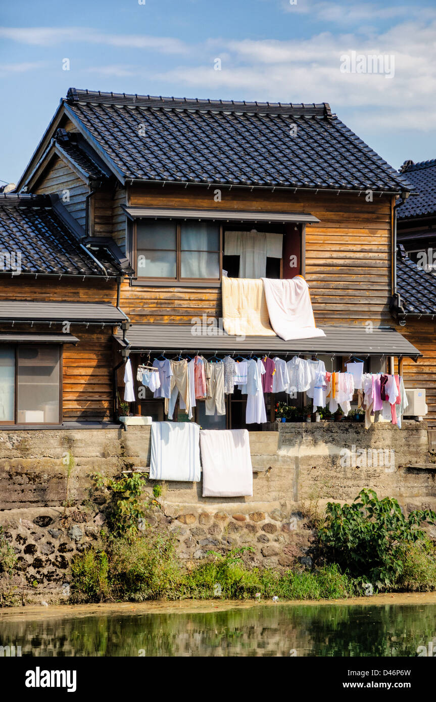 Jour de lessive au Japon : la pendaison de laver les fenêtres d'une maison japonaise traditionnelle en bois, près de la rivière Banque D'Images