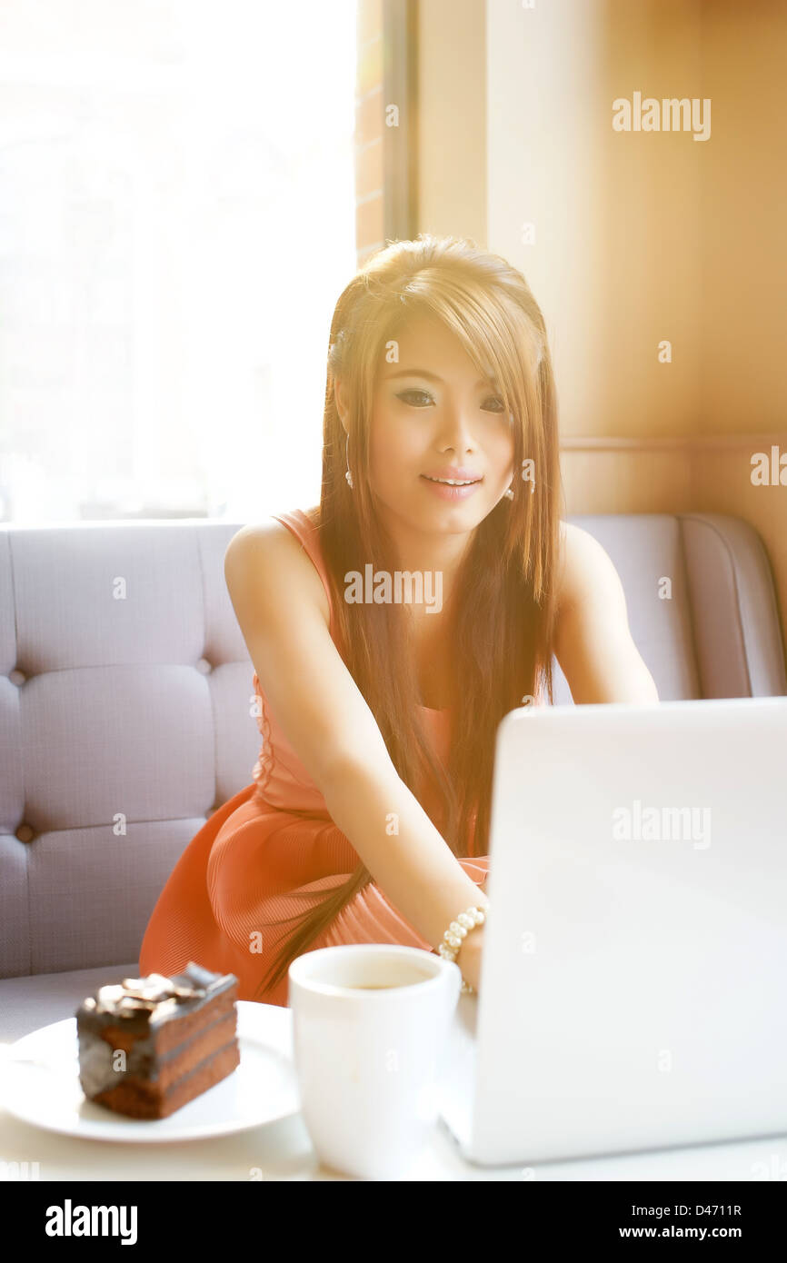 Young business woman sitting in cafe avec son ordinateur portable. Banque D'Images