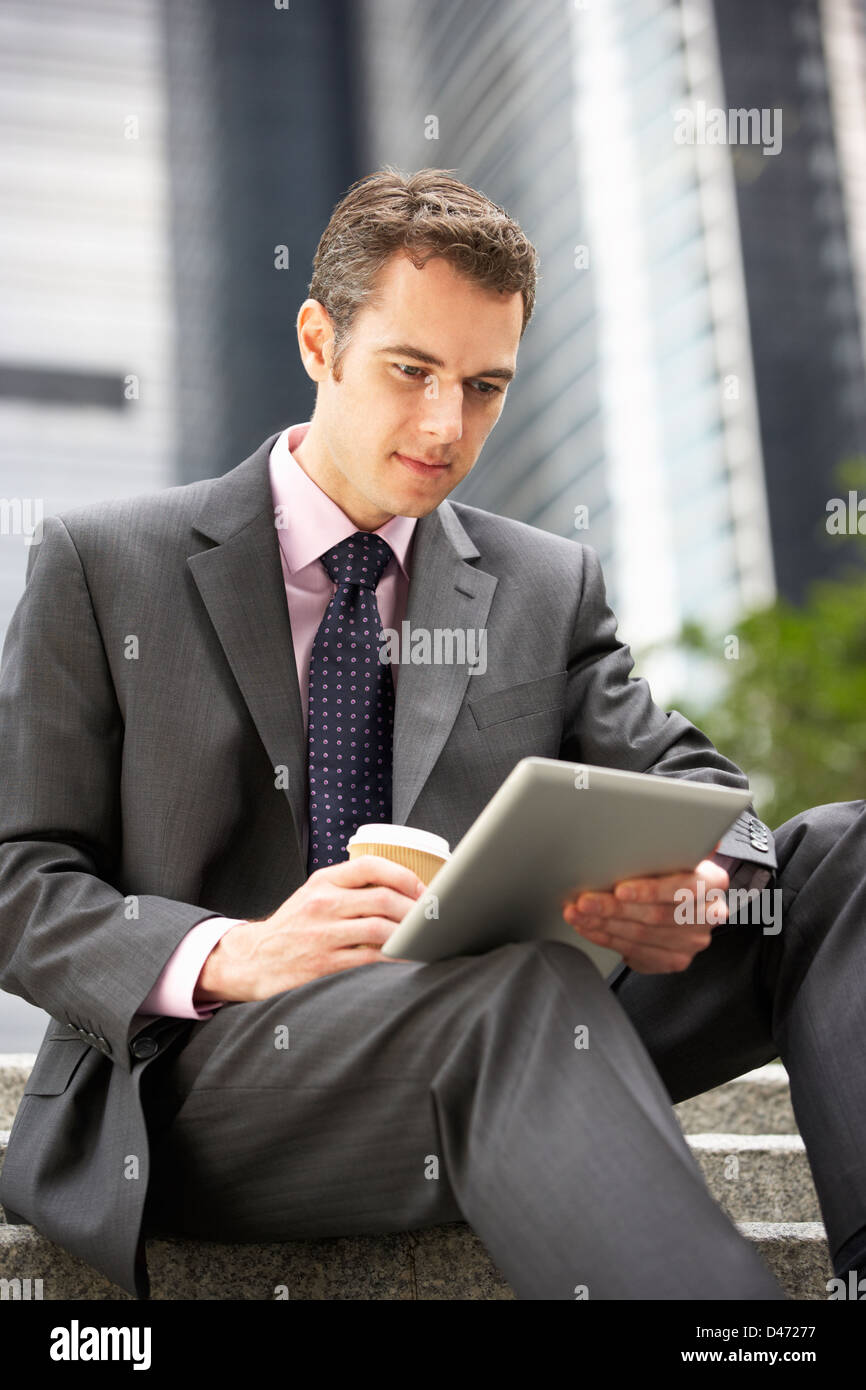 Businessman Working On Laptop Bureau extérieur avec du café à emporter Banque D'Images