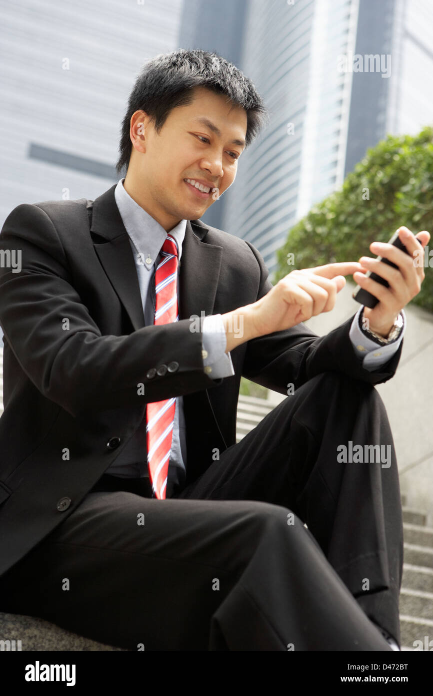 Chinese Businessman vocale sur le téléphone mobile à l'extérieur du bureau Banque D'Images