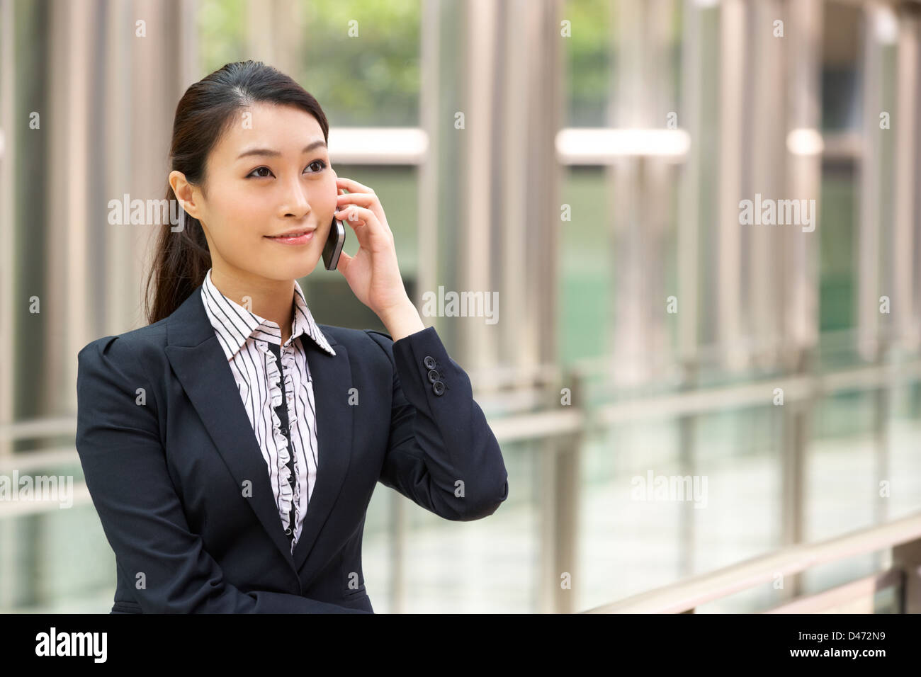 Chinese Businesswoman Outside Office On Mobile Phone Banque D'Images