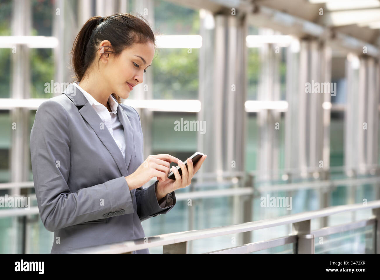 Hispanic Businesswoman Outside Office On Mobile Phone Banque D'Images