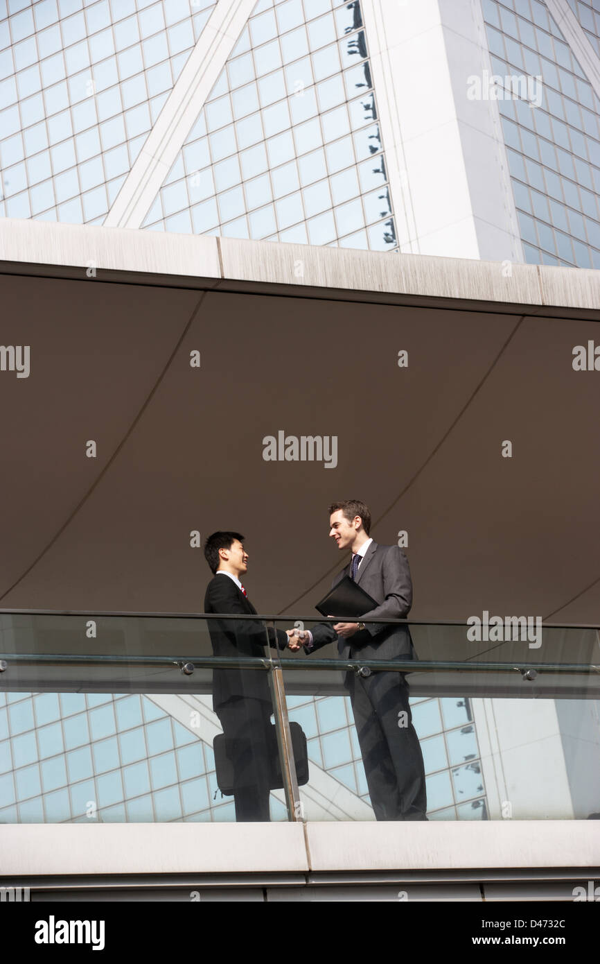 Deux Businessmen Shaking Hands Outside Office Building Banque D'Images