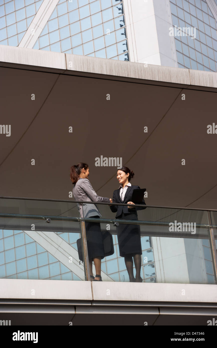 Two Businesswomen Shaking Hands Outside Office Building Banque D'Images