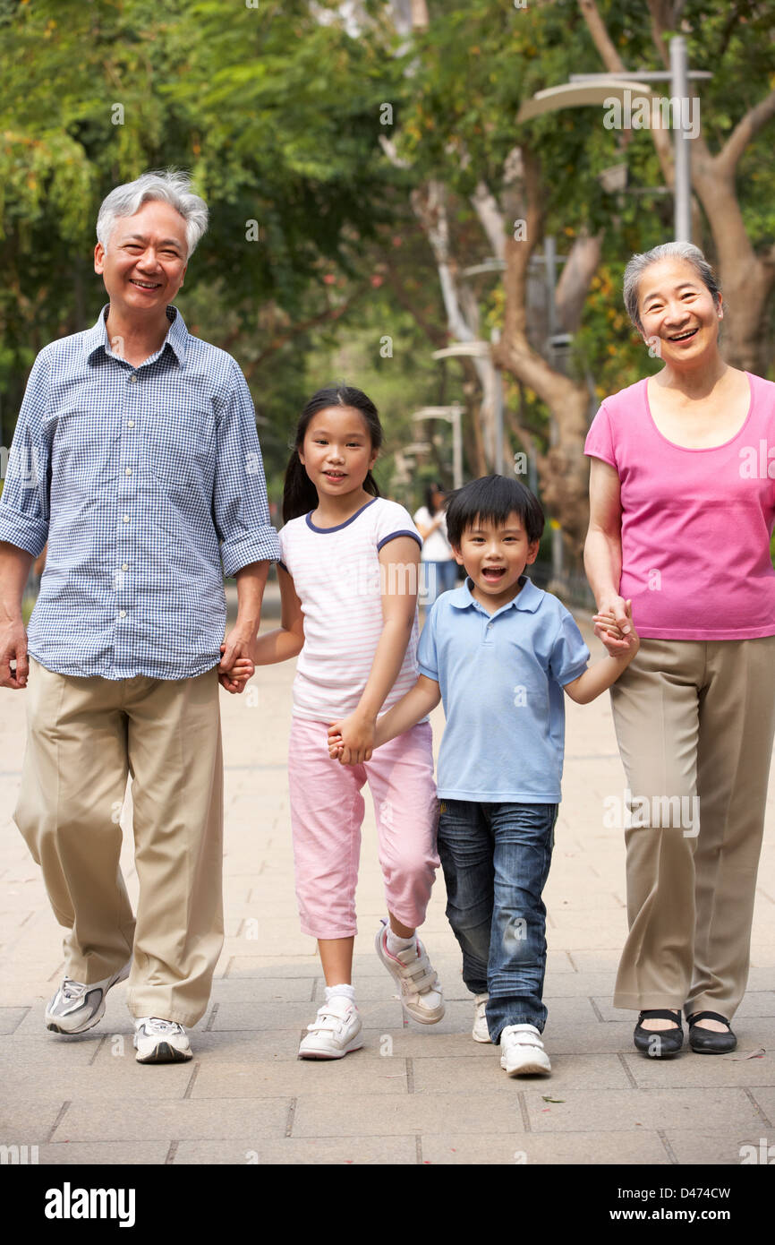 Les grands-parents chinois marcher dans parc avec petits-enfants Banque D'Images