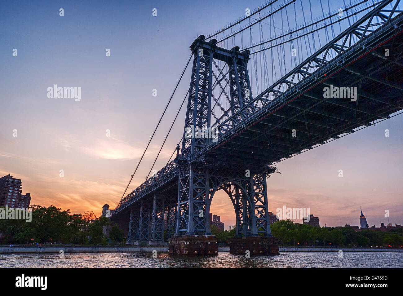 New York City Manhattan du pont sur la rivière de l'Est à l'horizon après le coucher du soleil . Banque D'Images