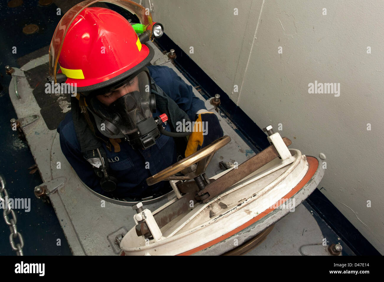 Un marin pénètre dans un espace confiné lors d'un exercice de contrôle des dommages causés par des gaz toxiques à bord d'un navire de la marine américaine dans le golfe Persique pour assurer la disponibilité en cas d'urgence. Banque D'Images
