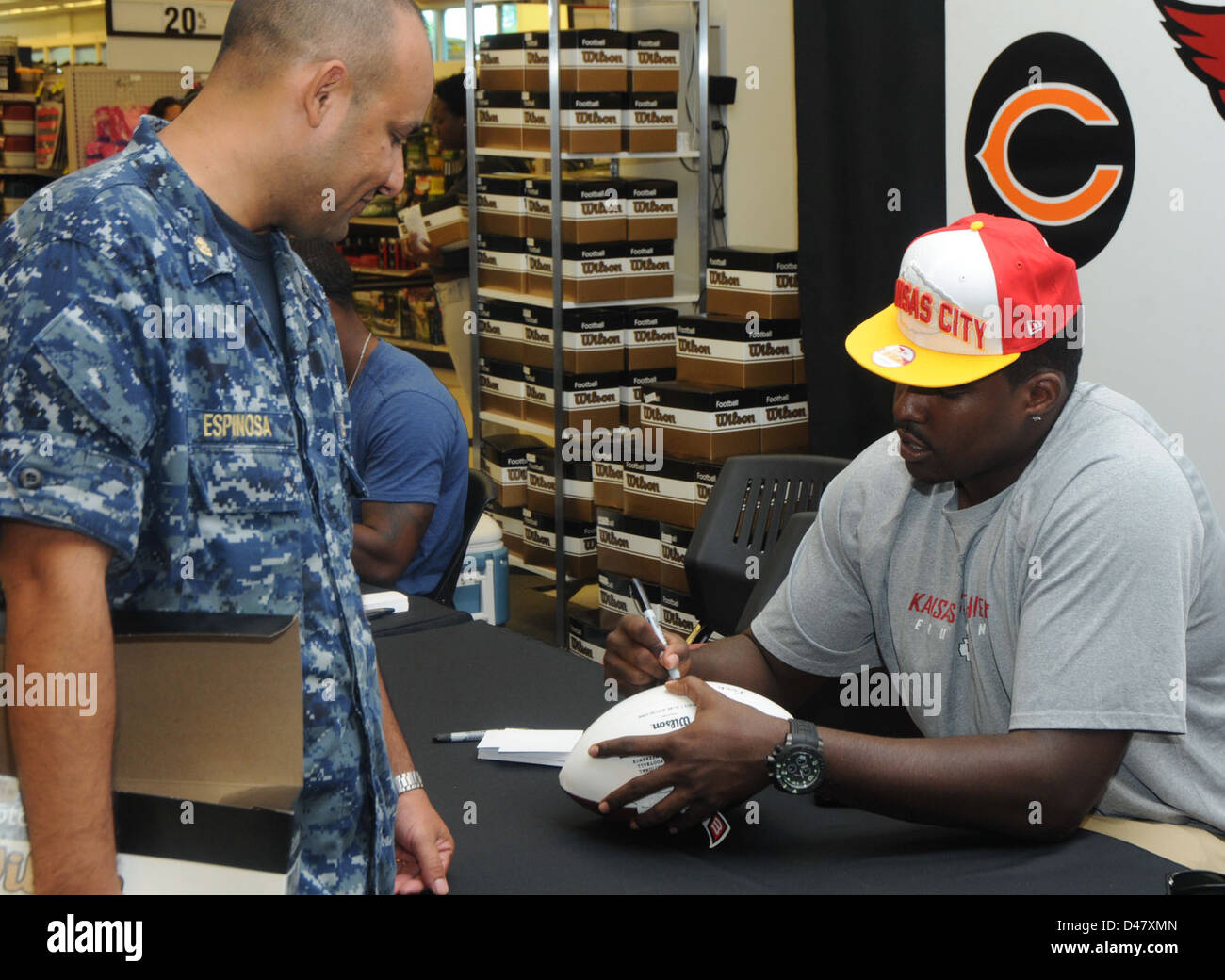 David Mims, attaquant de gauche pour les Chiefs de Kansas City, signe un ballon de football pour un marin de la marine américaine, soulignant le lien entre le sport professionnel et les membres du service militaire. Cette interaction reflète l'appréciation et le soutien entre les deux communautés. Banque D'Images David Mims, attaquant de gauche pour les Chiefs de Kansas City, signe un ballon de football pour un marin de la marine américaine, soulignant le lien entre le sport professionnel et les membres du service militaire. Cette interaction reflète l'appréciation et le soutien entre les deux communautés. Banque D'Images