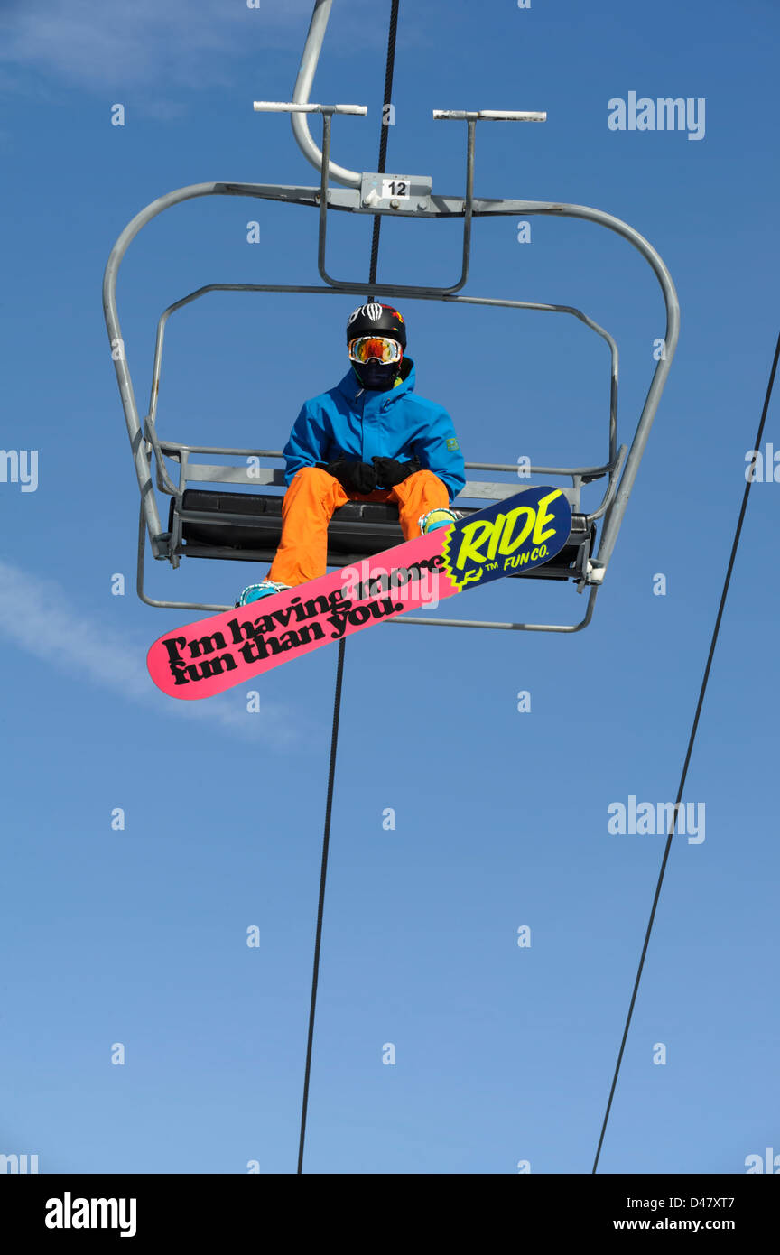 Snowboarder équitation hiver ski ascenseur pris de dessous avec rose coloré amusant avec expression. Banque D'Images