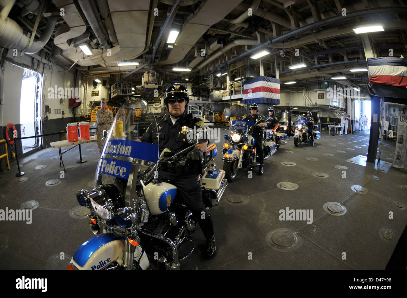 Les policiers de Boston conduisent des motos de service à l'intérieur de la baie de hangar de l'USS Wasp pendant la Boston Navy week 2012. Cet événement a mis en valeur la collaboration entre les forces de l'ordre locales et la marine américaine tout en mettant l'accent sur la sécurité publique et la participation communautaire. Banque D'Images