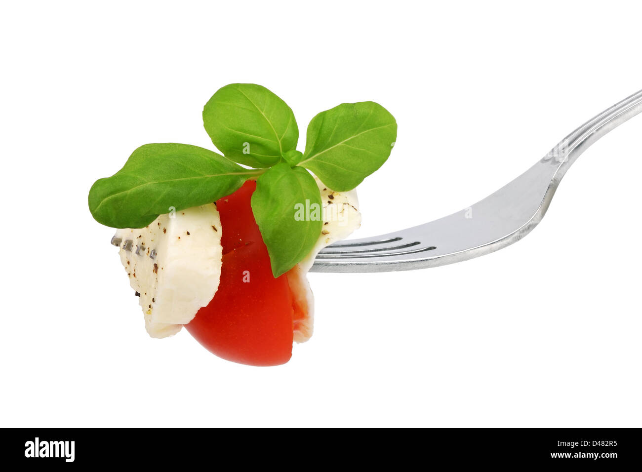 Salade italienne sur une fourche sur fond blanc Banque D'Images
