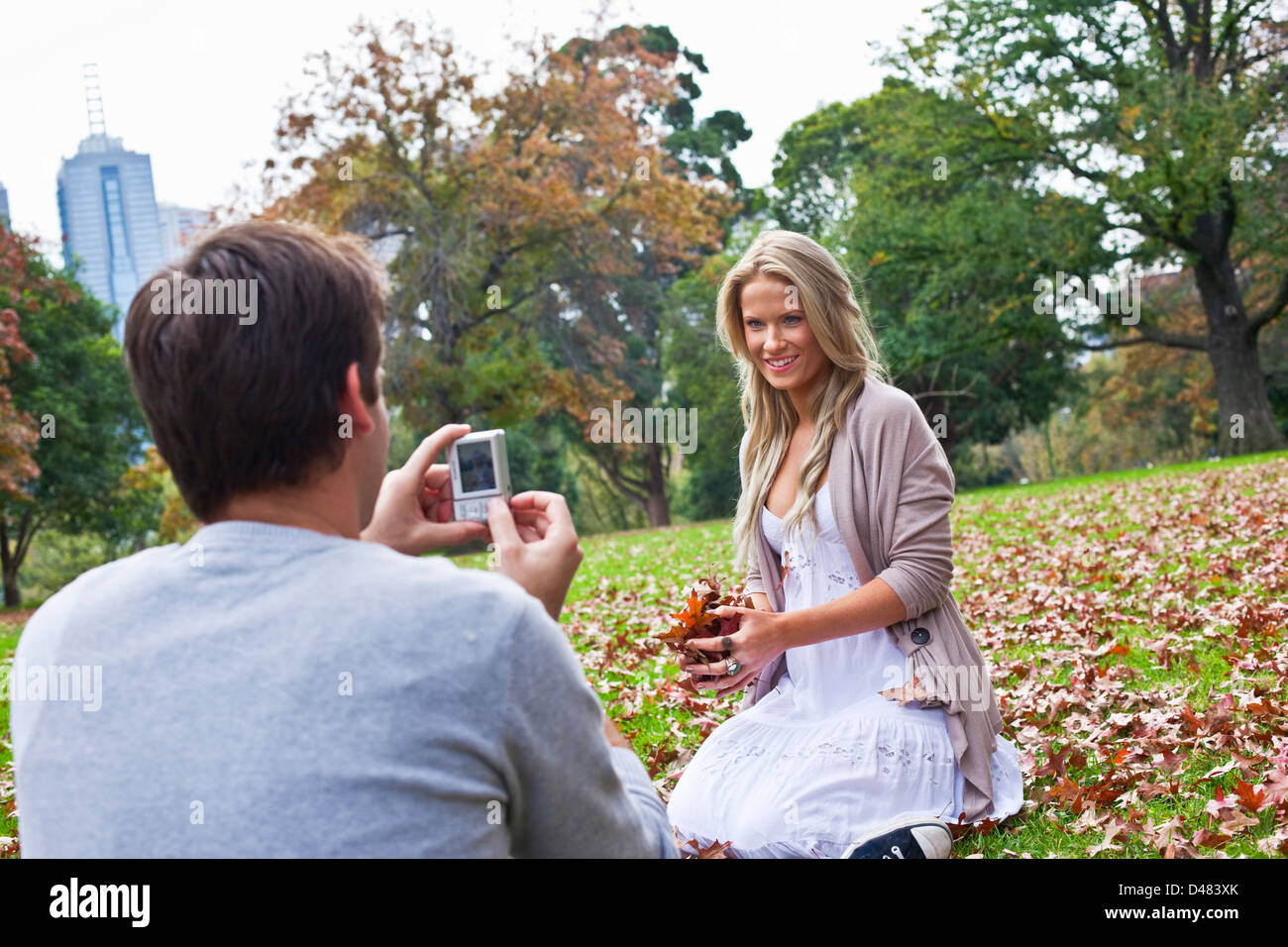 Jeune couple s'amusant avec les feuilles d'automne au parc. Melbourne, Victoria, Australie Banque D'Images