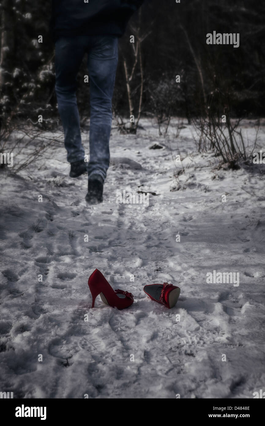 Red High heels dans la neige, c'est l'homme en fuite Banque D'Images