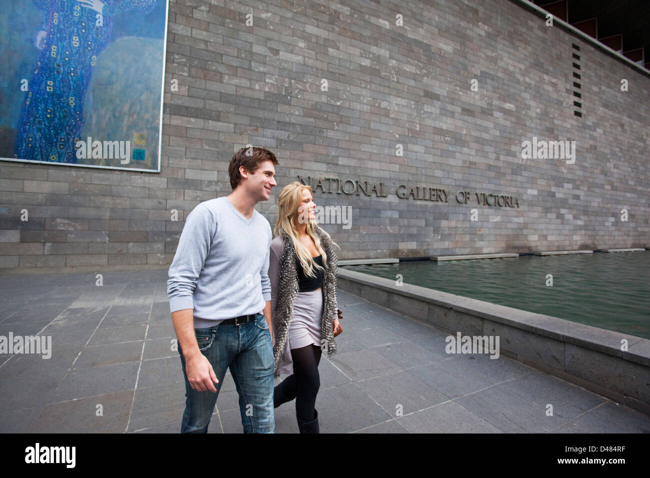 Jeune couple marchant à l'extérieur de la National Gallery of Victoria. Melbourne, Victoria, Australie Banque D'Images