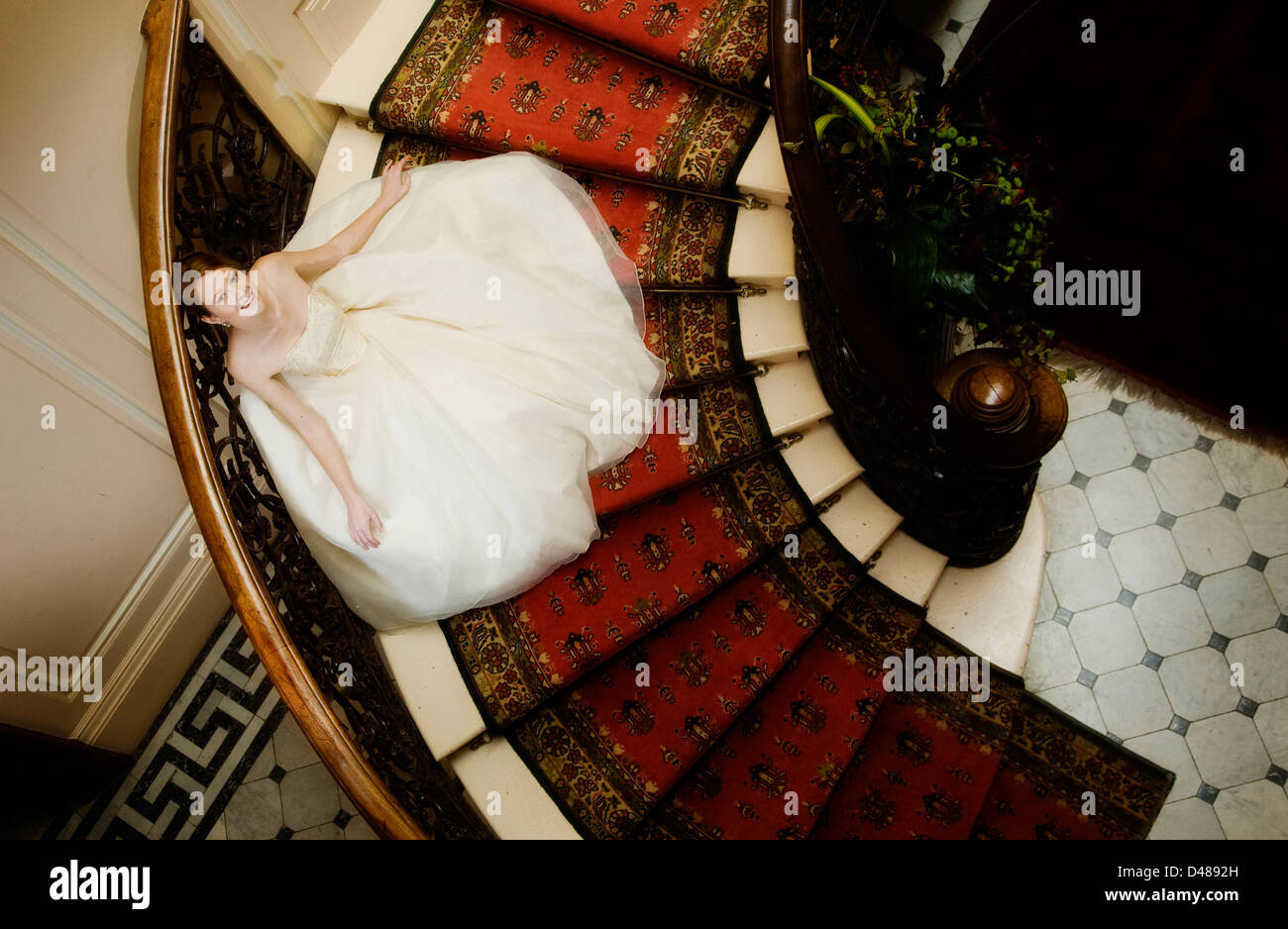 Mariée photographié d'escalier ornementé sur ci-dessus avec plein de crème à jupe robe de mariage sans bretelles Banque D'Images