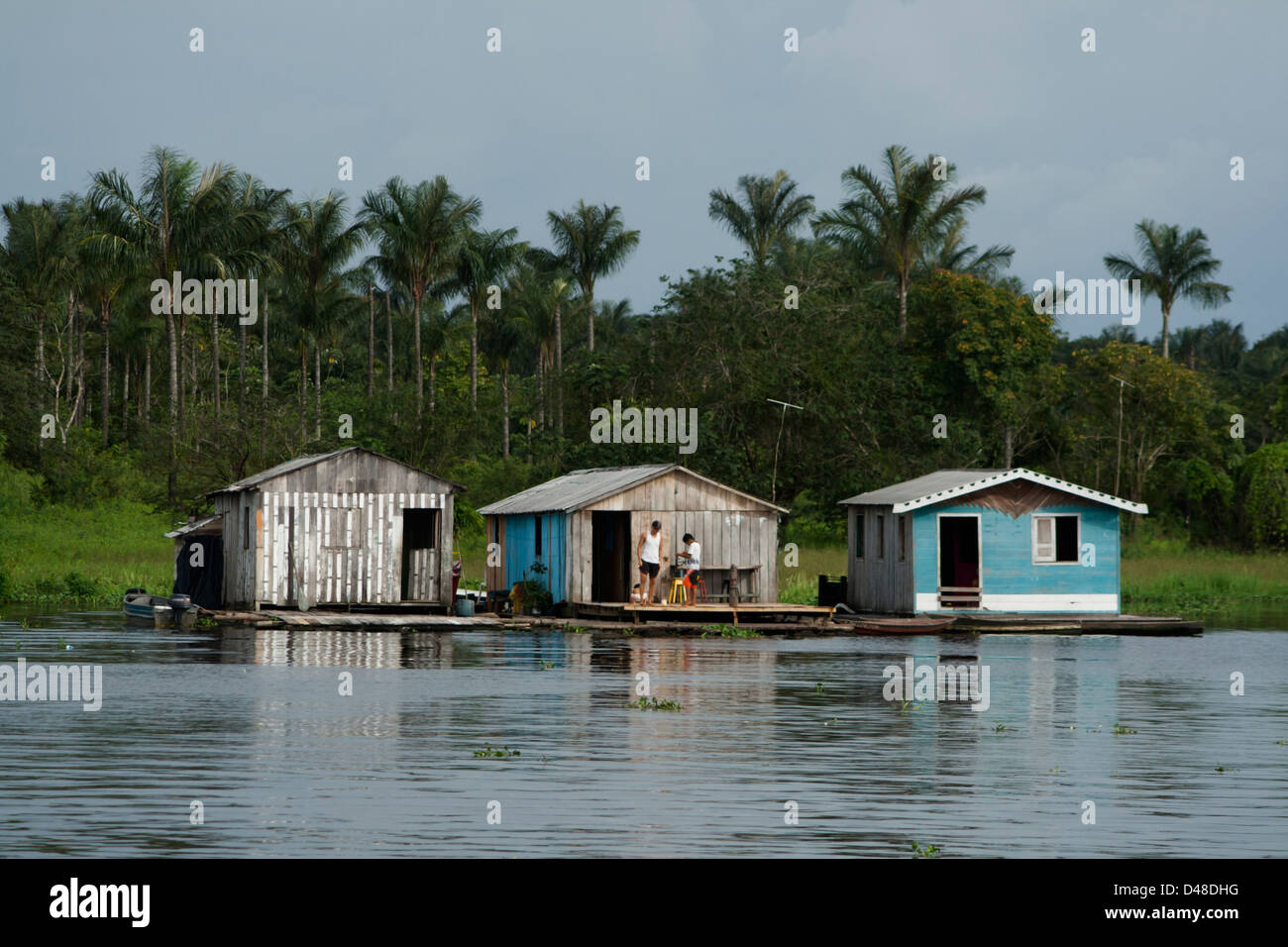 Les maisons flottantes et les gens l'aviron en petites pirogues près de Manaus, ville du nord, l'état de l'Amazone au Brésil. Banque D'Images