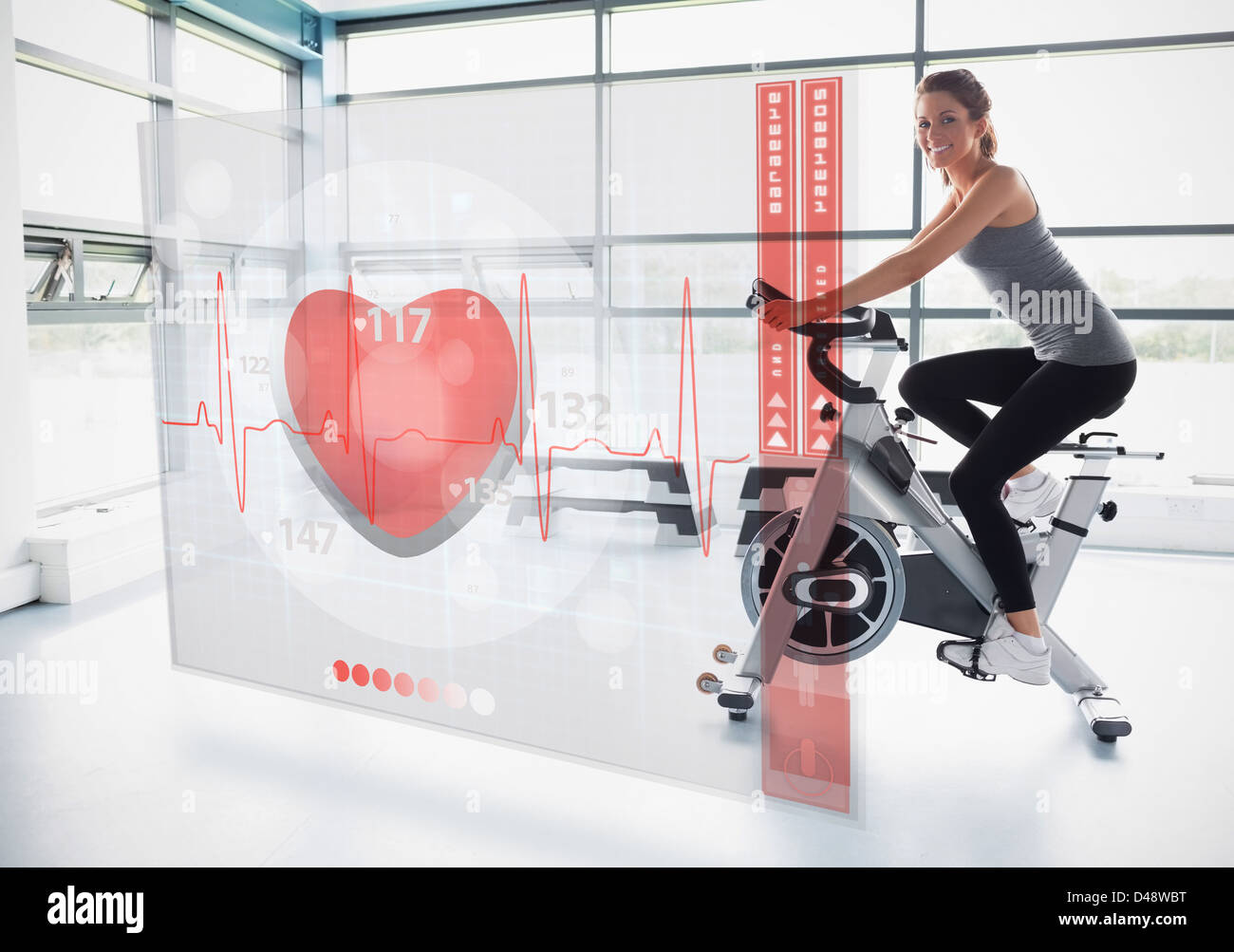 Young Girl doing exercise bike with futuristic interface Banque D'Images