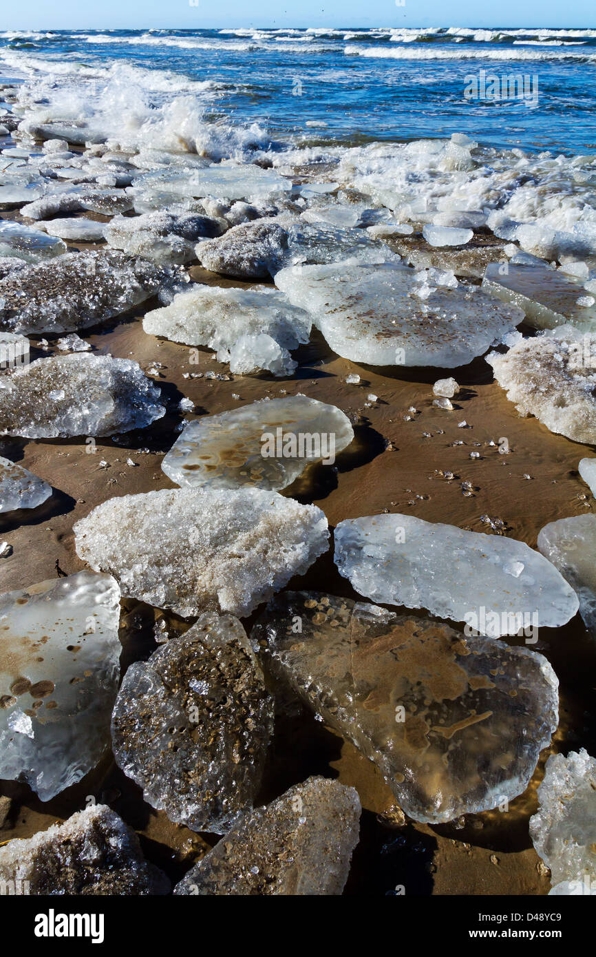 Gros fragments de banquise et de glace sur la plage de sable, lancées par la grosses vagues de mer, mer Baltique. Banque D'Images