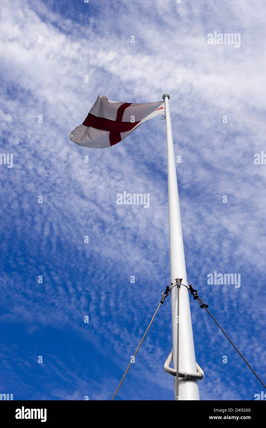 Drapeau anglais de St George battant en haut du mât contre le ciel bleu Banque D'Images