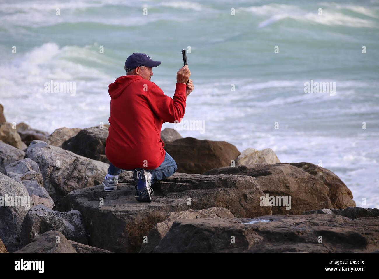 Un homme ou une personne prenant des photos des photos de l'océan avec un ipad tablet Banque D'Images