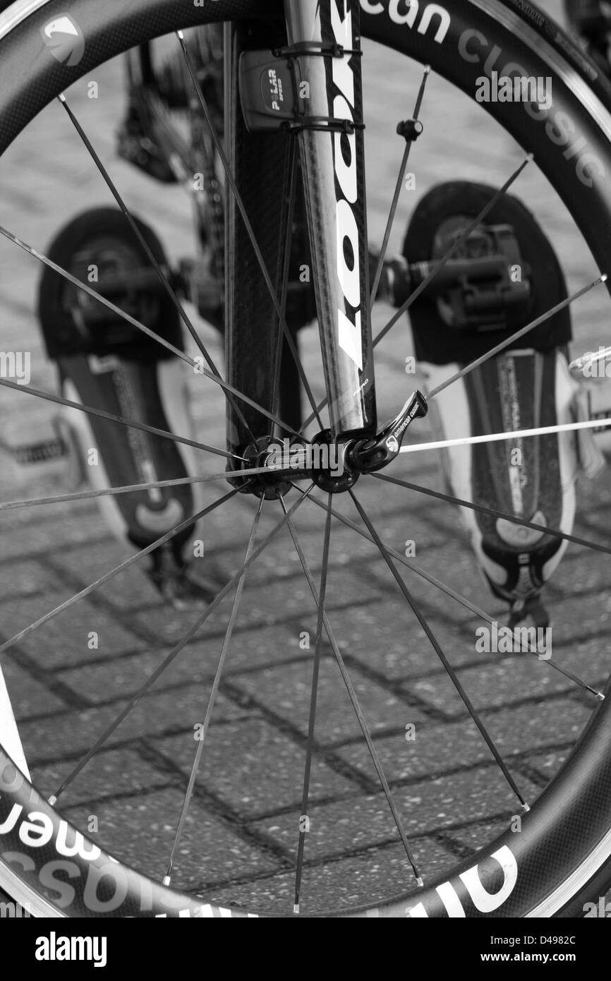Chaussures route vélo clipsés et vu à travers la roue avant Banque D'Images