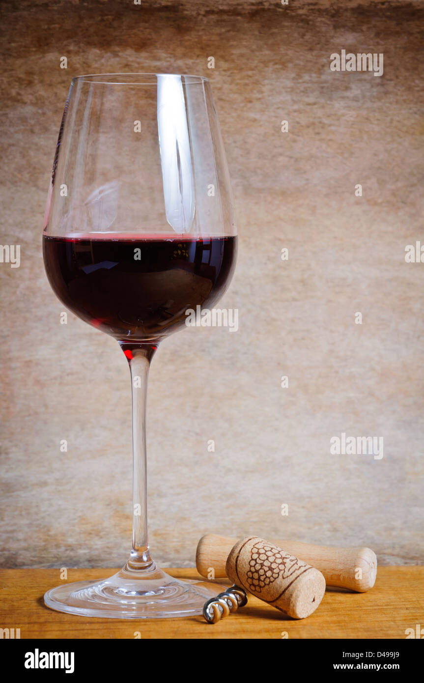 Verre de vin rouge avec du liège et tire-bouchon on a wooden background Banque D'Images