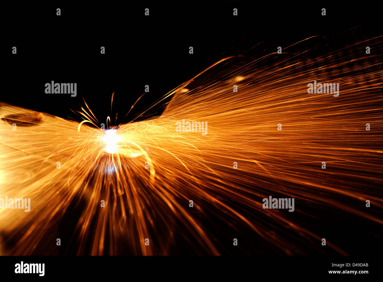 Thème industriel montrant une machine de découpe laser au travail, dans le noir de retour avec beaucoup d'étincelles brillantes Banque D'Images