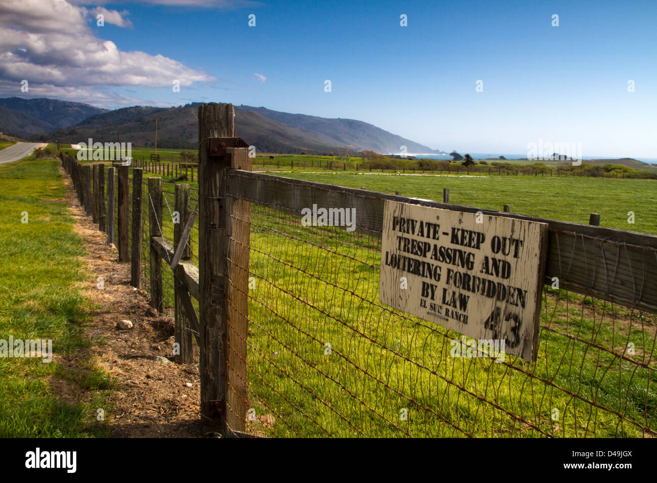 Une clôture et une salle, garder hors de signer le long de la route un à Big Sur, Californie, USA. Banque D'Images