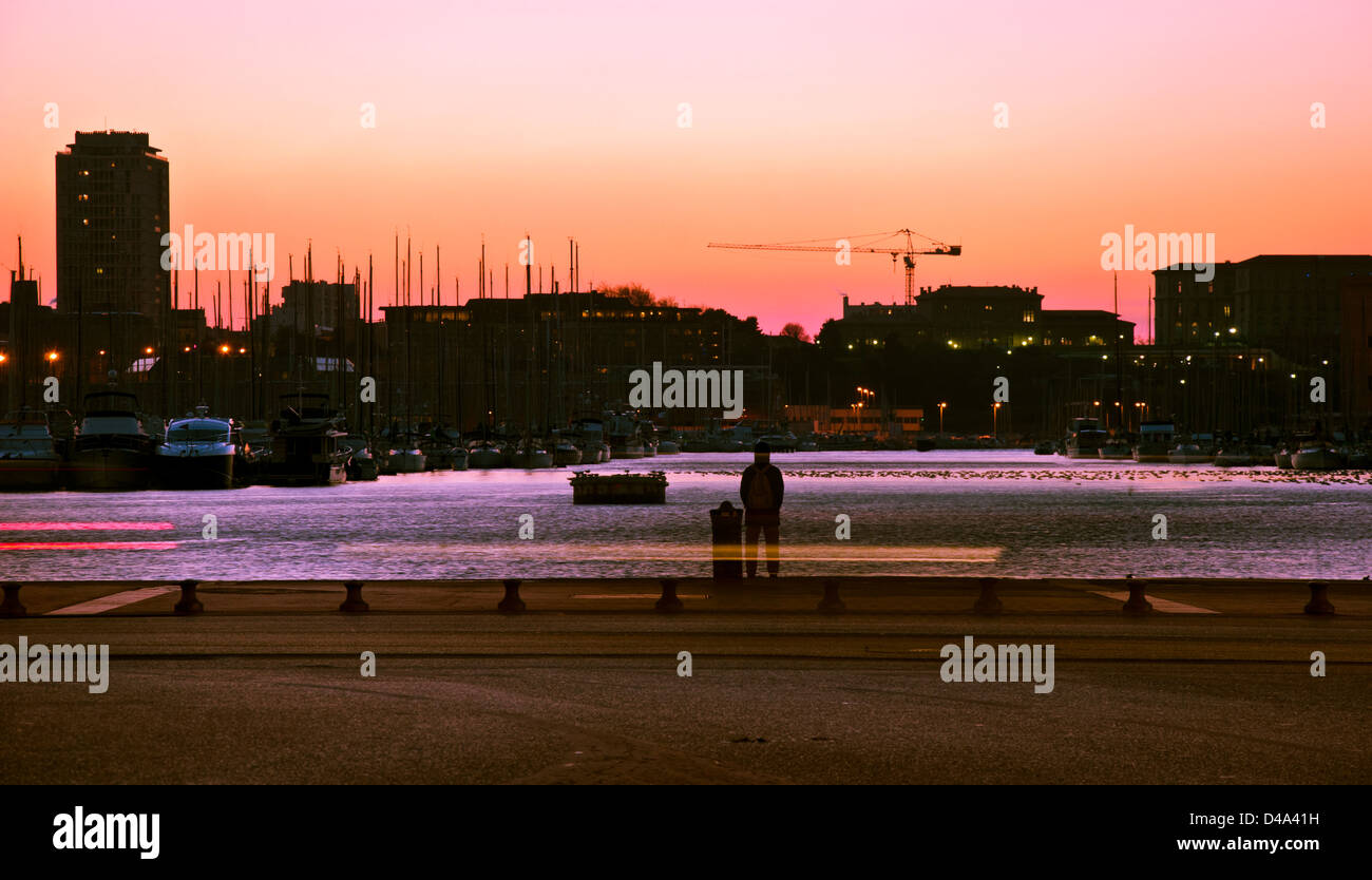 Marseille, France, Provence : vue du coucher de soleil d'une personne inconnue debout dans le port. Banque D'Images