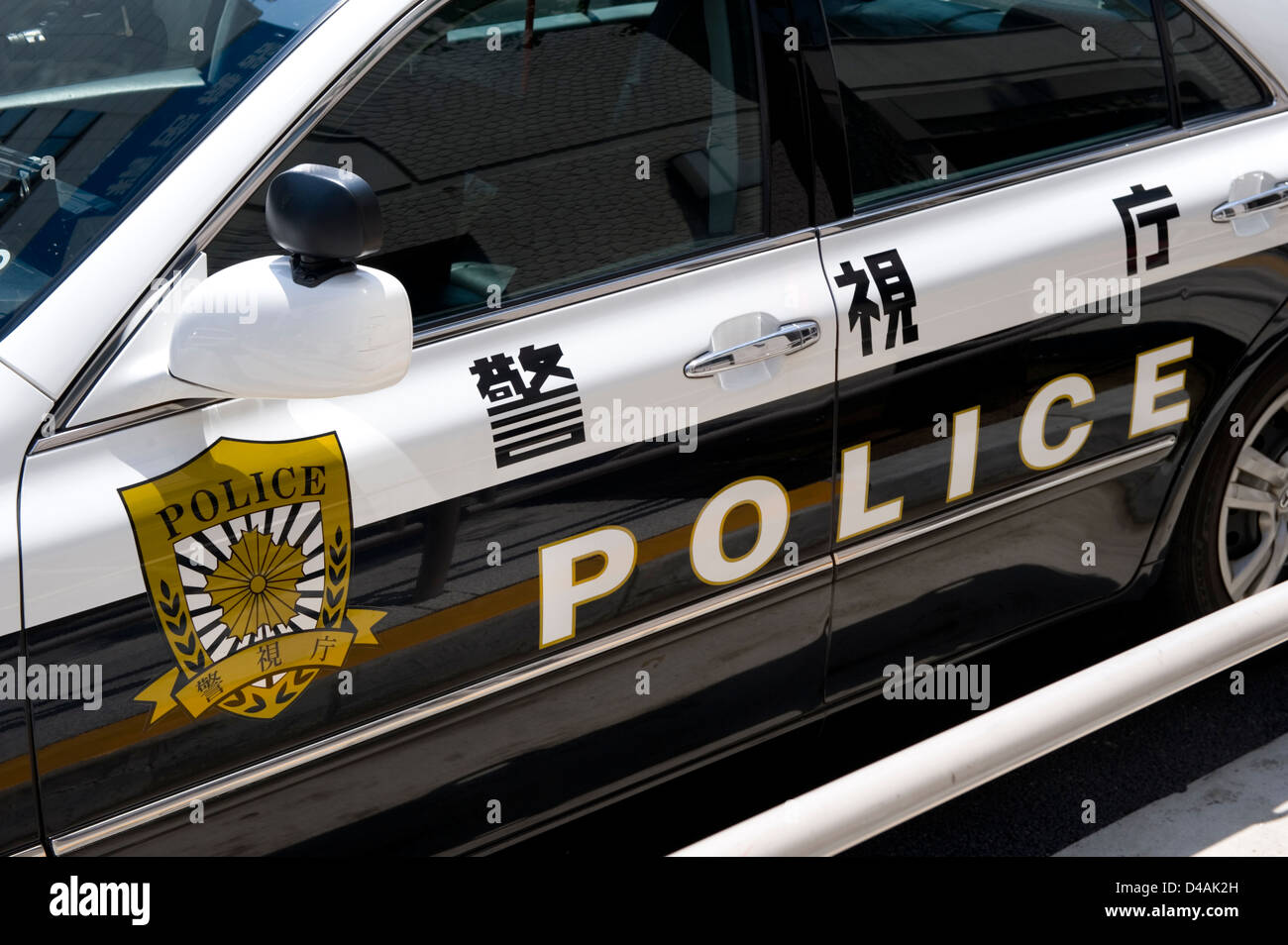 Détail de la voiture de police avec l'anglais langues écrites sur la porte à Tokyo, Japon Banque D'Images