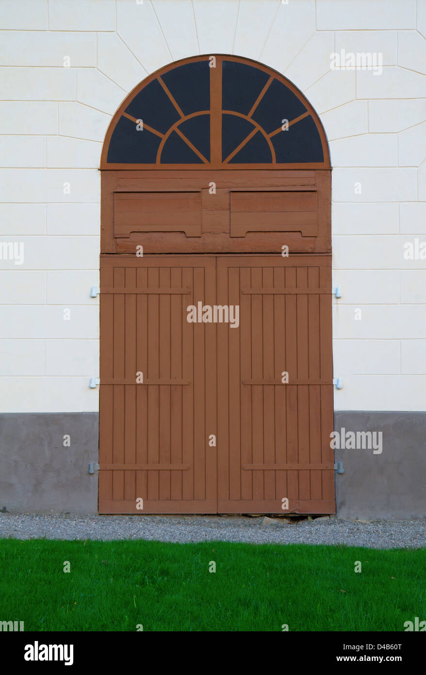 Brown portes de grange en pierre mur blanc Banque D'Images
