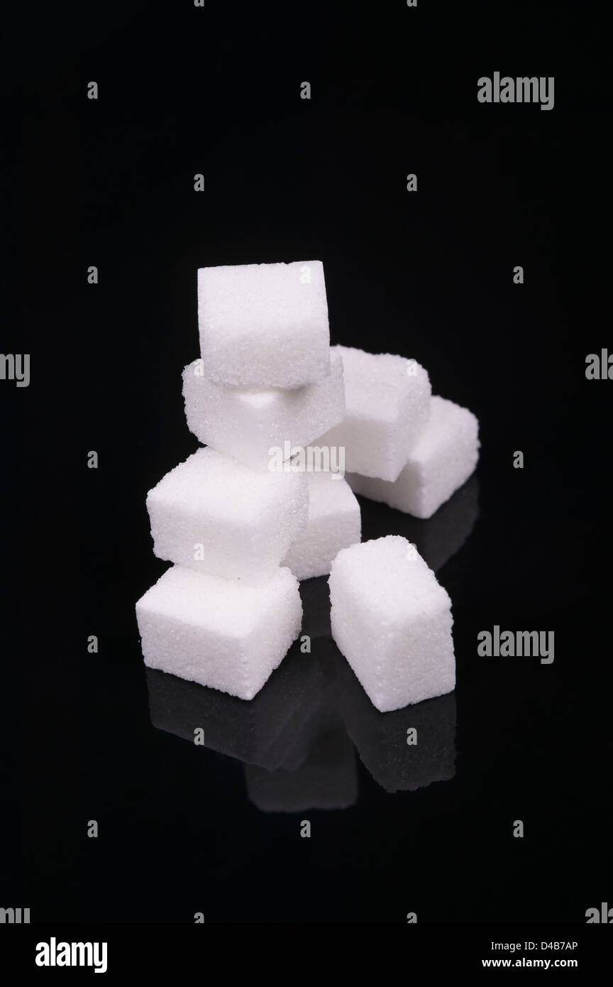 Photo de cube de sucre isolé sur un fond noir Banque D'Images