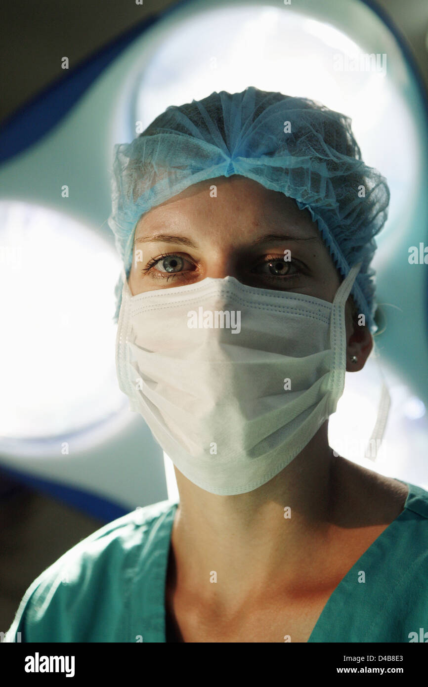 Chirurgienne donne directement à l'appareil photo de sous les feux chirurgicale Banque D'Images
