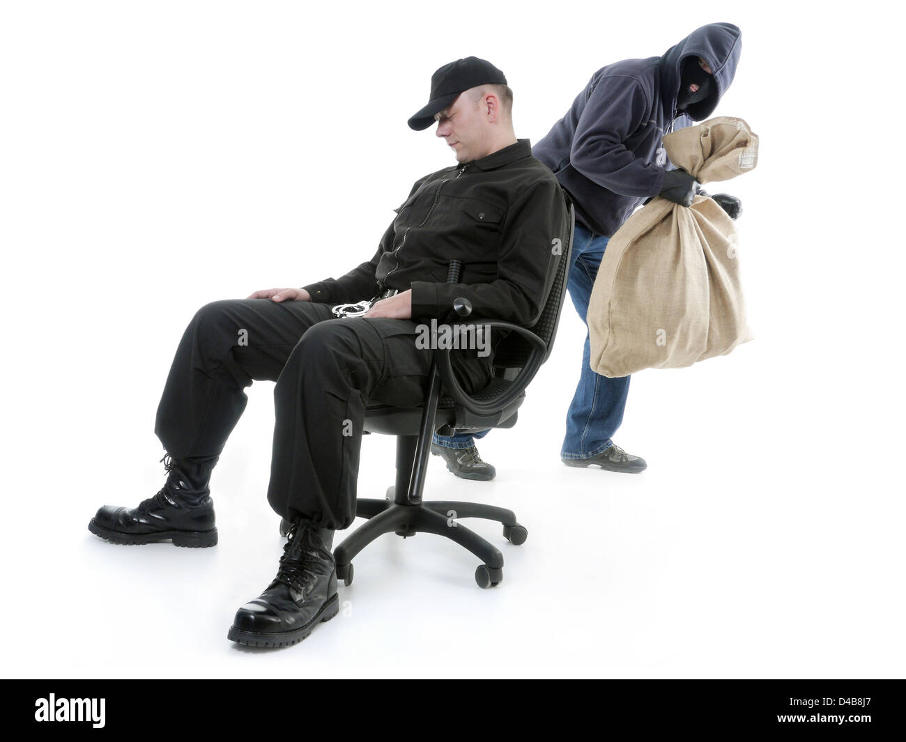 L'homme sécurité dormir sur un fauteuil n'étant pas au courant du vol de cambrioleur masqué derrière son dos Banque D'Images