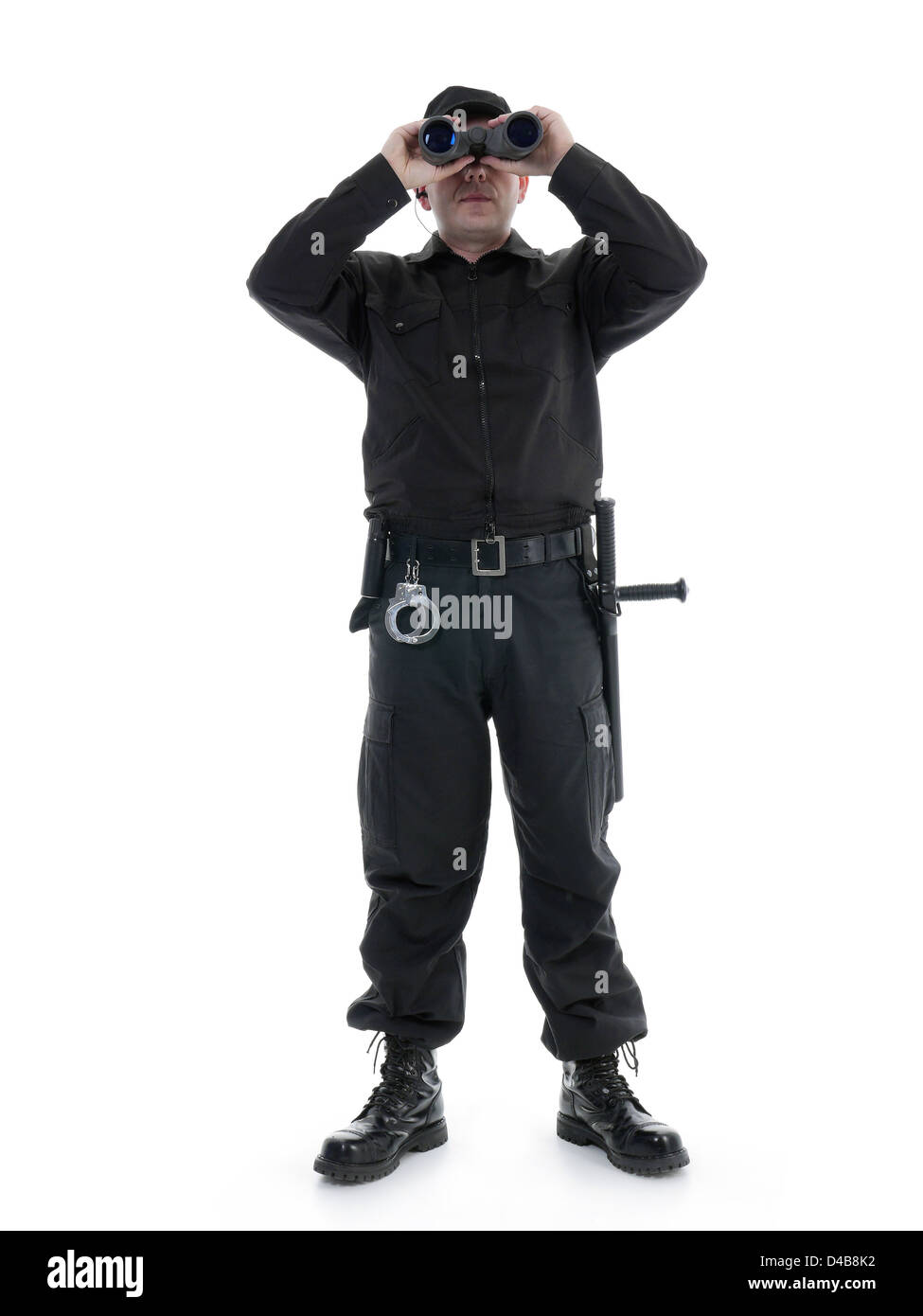Homme portant uniforme de sécurité noir regardant à travers des jumelles, shot on white Banque D'Images