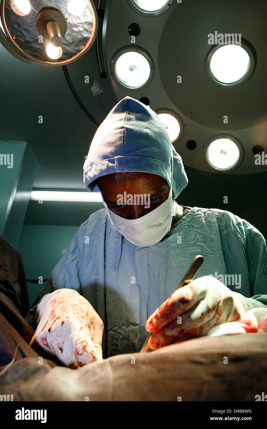 Exploitation chirurgien sur patient sous utilisation de l'éclairage. Le Soudan, l'Afrique. Banque D'Images