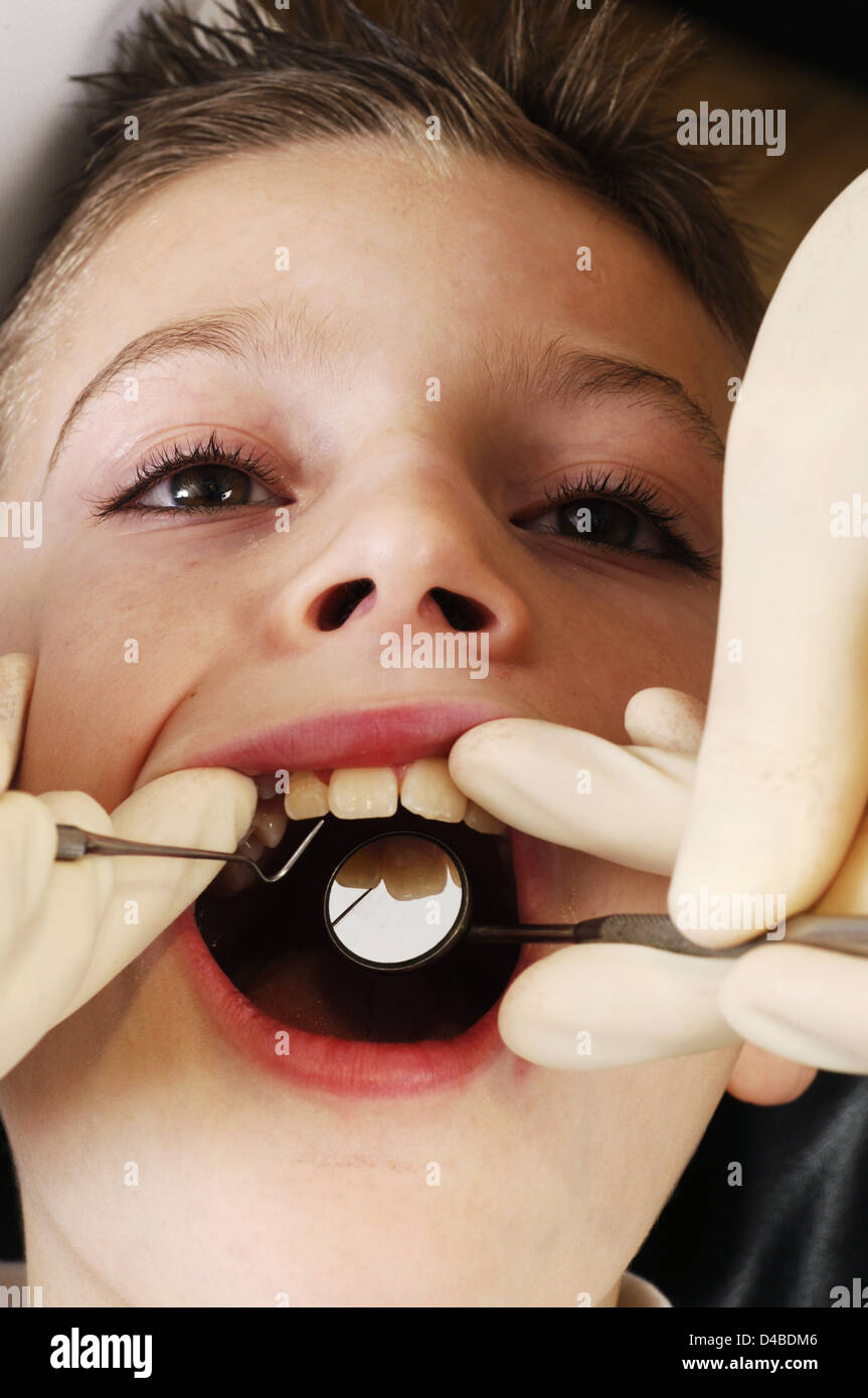 Dentiste l'inspection avant le traitement de la bouche des garçons Banque D'Images
