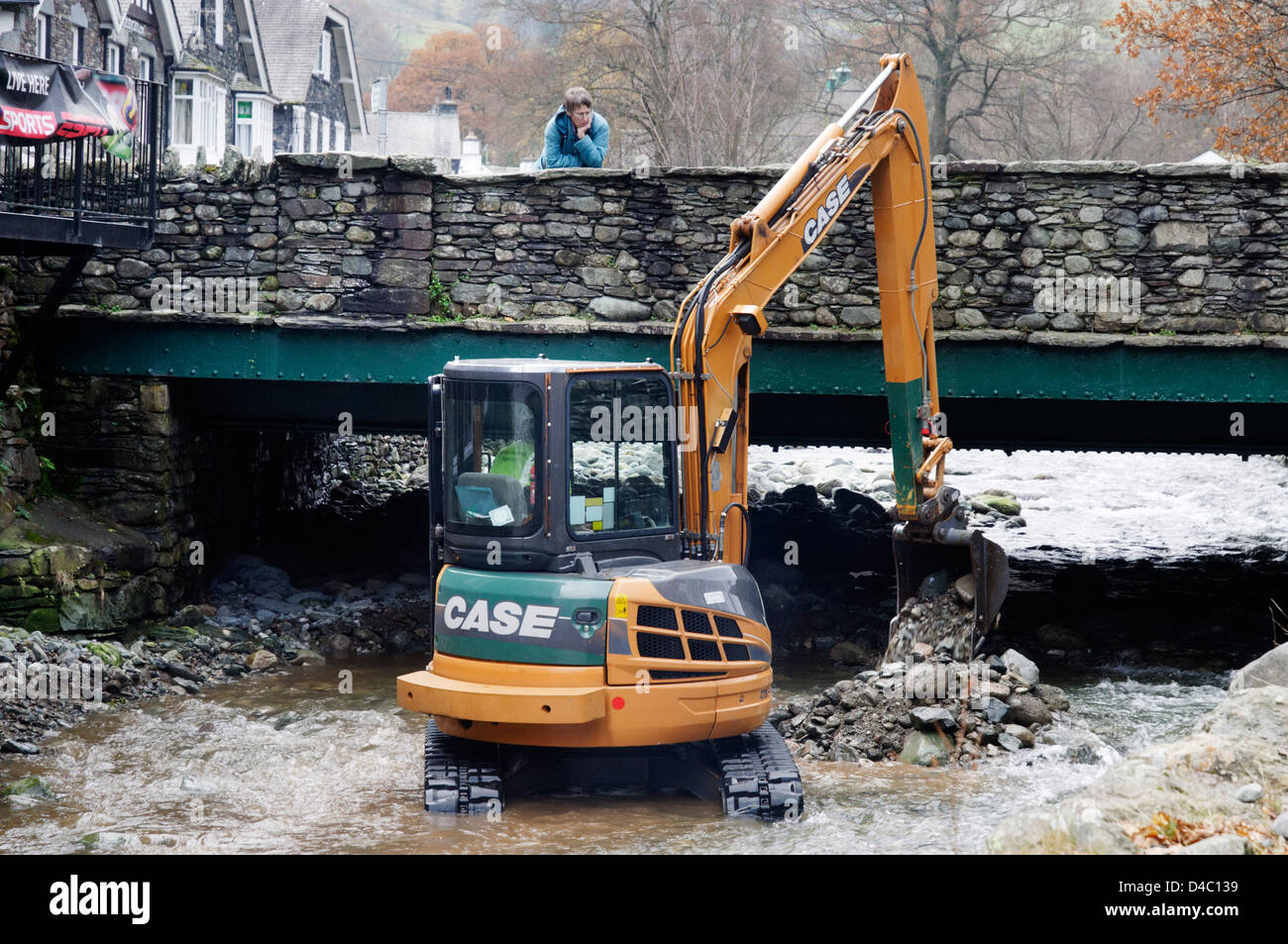 Un type JCB digger travaillant dans une rivière de Penrith, le Lake District, en Angleterre Banque D'Images