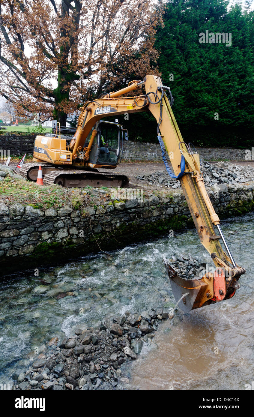 Un type JCB digger travaillant dans une rivière de Penrith, le Lake District, en Angleterre Banque D'Images