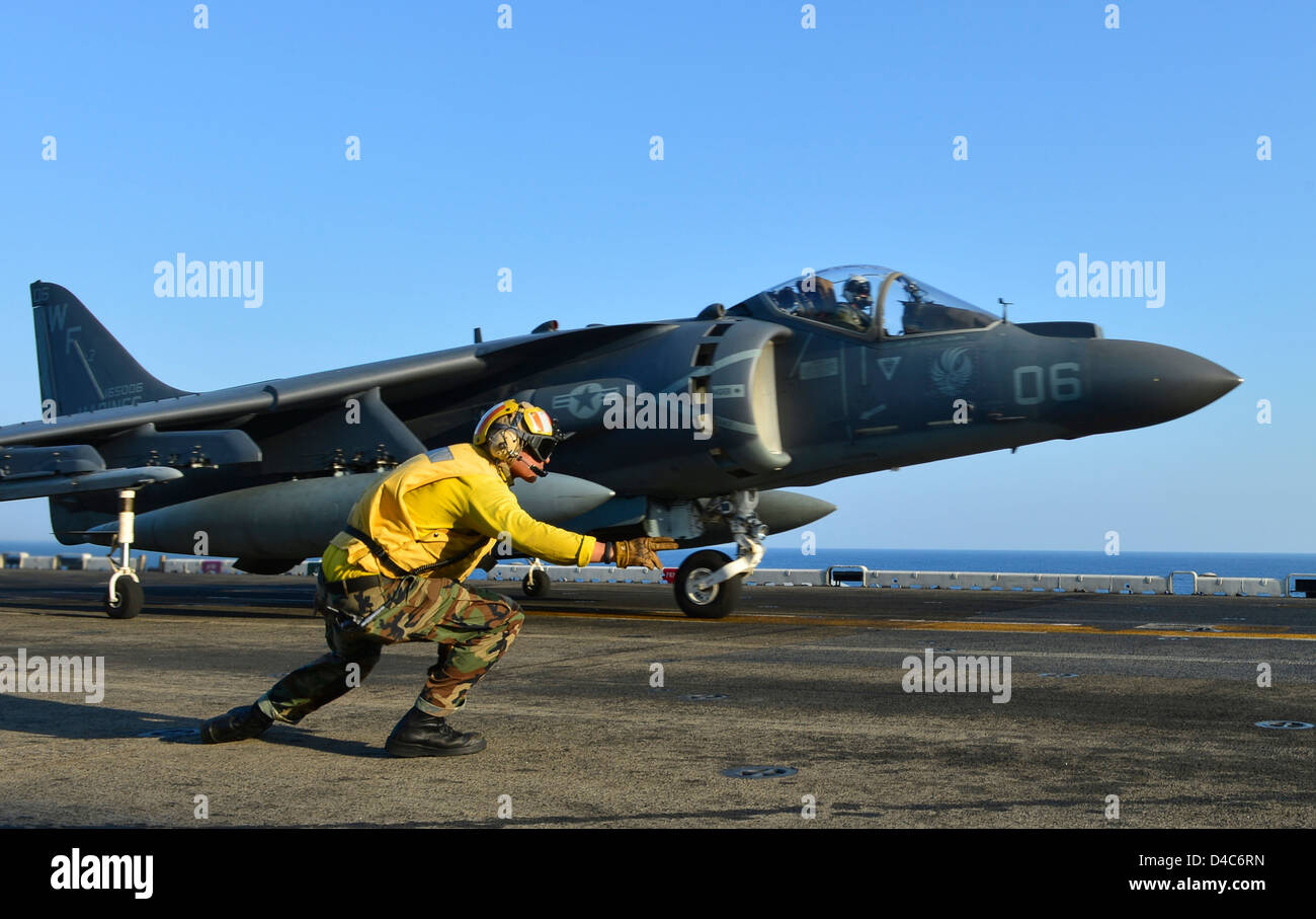 L'Aviation de l'US Navy UN Manœuvrier ordonne à un AV-8B Harrier jet fighter aircraft à lancer dans le poste de pilotage de l'assaut amphibie USS Bonhomme Richard le 8 mars 2013 dans l'océan Pacifique. Banque D'Images