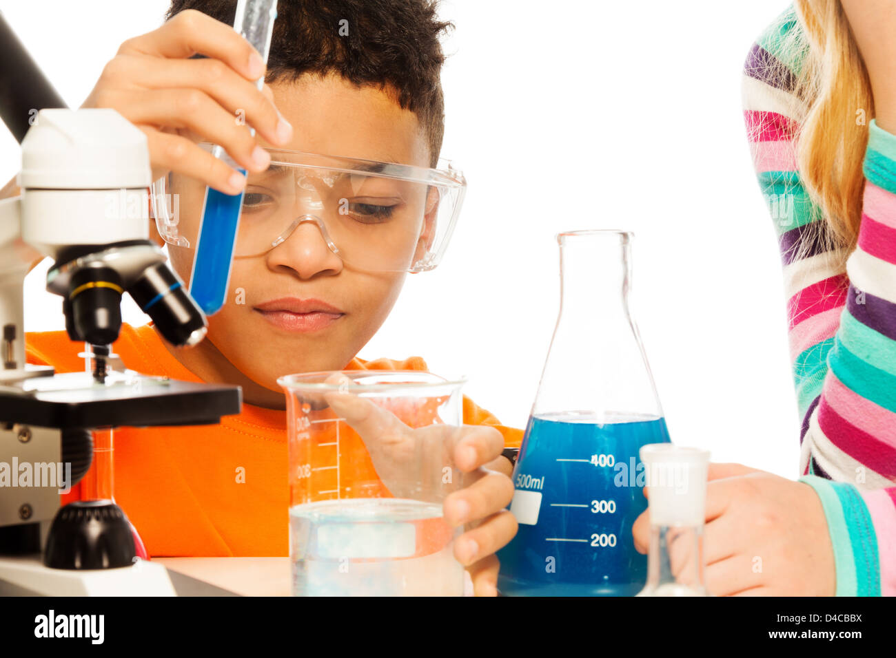 Garçon et chimie - 8 ans mélanger les liquides dans des flacons et tubes à essai Banque D'Images