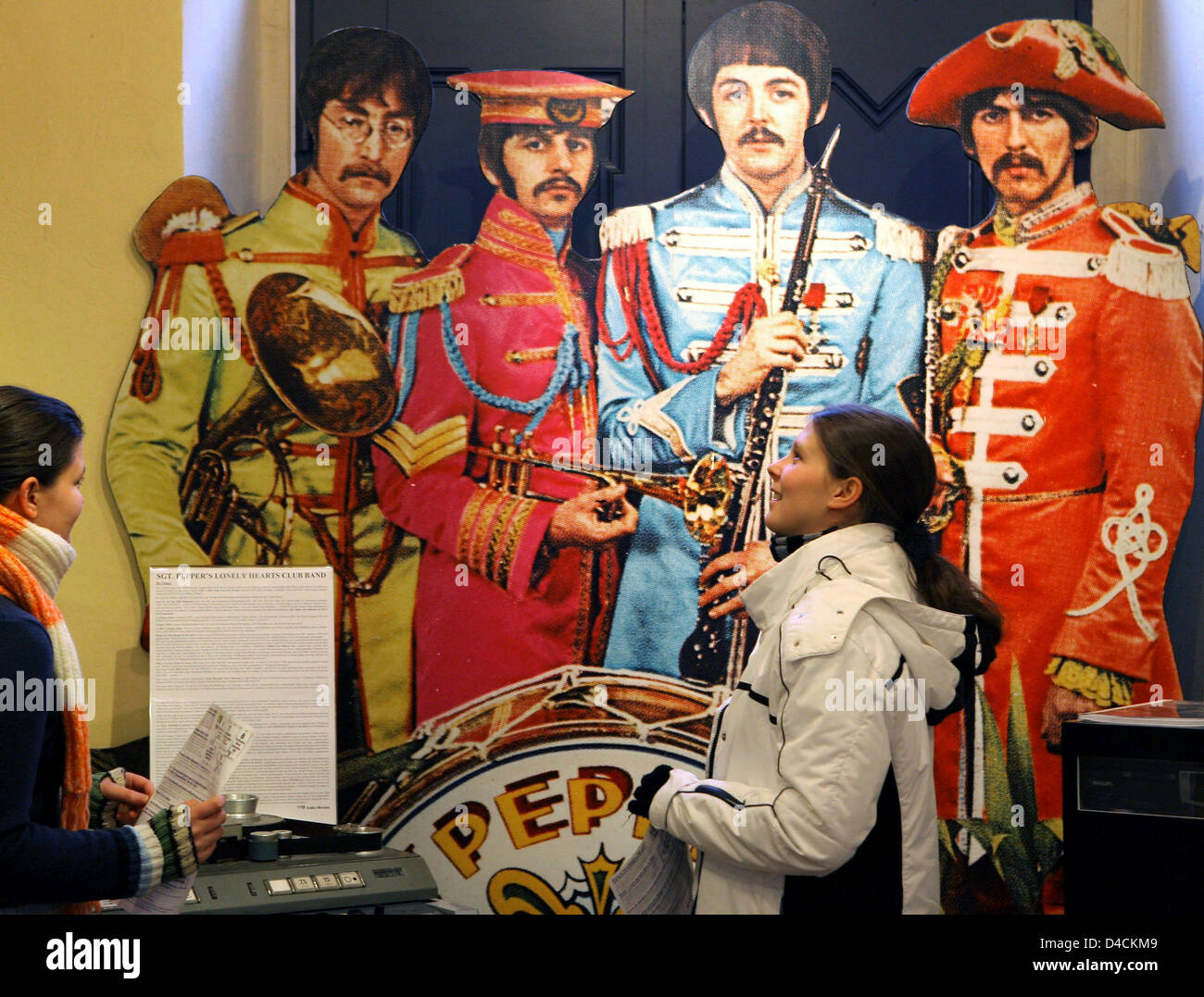 Les visiteurs se tenir en face de la grande image de couverture de l'enregistrement 1967 'Sgt. Pepper's Lonely Hearts Club Band", montrant les musiciens légendaires John Lennon, Paul Mc Cartney, George Harrison et Ringo Starr, de Liverpool à la musée des Beatles à Halle (Saale), Allemagne, 03 janvier 2008. Le musée possède plus de 20 000 pièces, dont les rares enregistrements, autographes, affiches, photos Banque D'Images