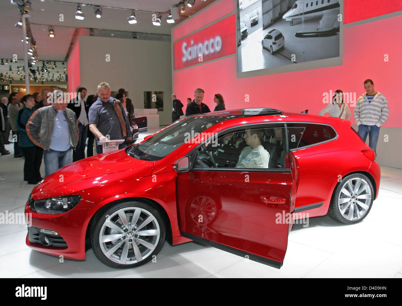 Les gens eye theVW Scirocco nouvelle édition à l'Auto Mobil International (AMI) de l'automobile à Leipzig, Allemagne, 06 avril 2008. Certaines marques de voiture 50 présentera un aperçu des nouveaux produits et développements avec plus de 100 premières mondiales attendues de 05 à 13 avril. La gamme de voitures s'étend des micro-voitures de limousines de luxe, d'une part, la famille de fourgonnettes, VUS à de super s Banque D'Images