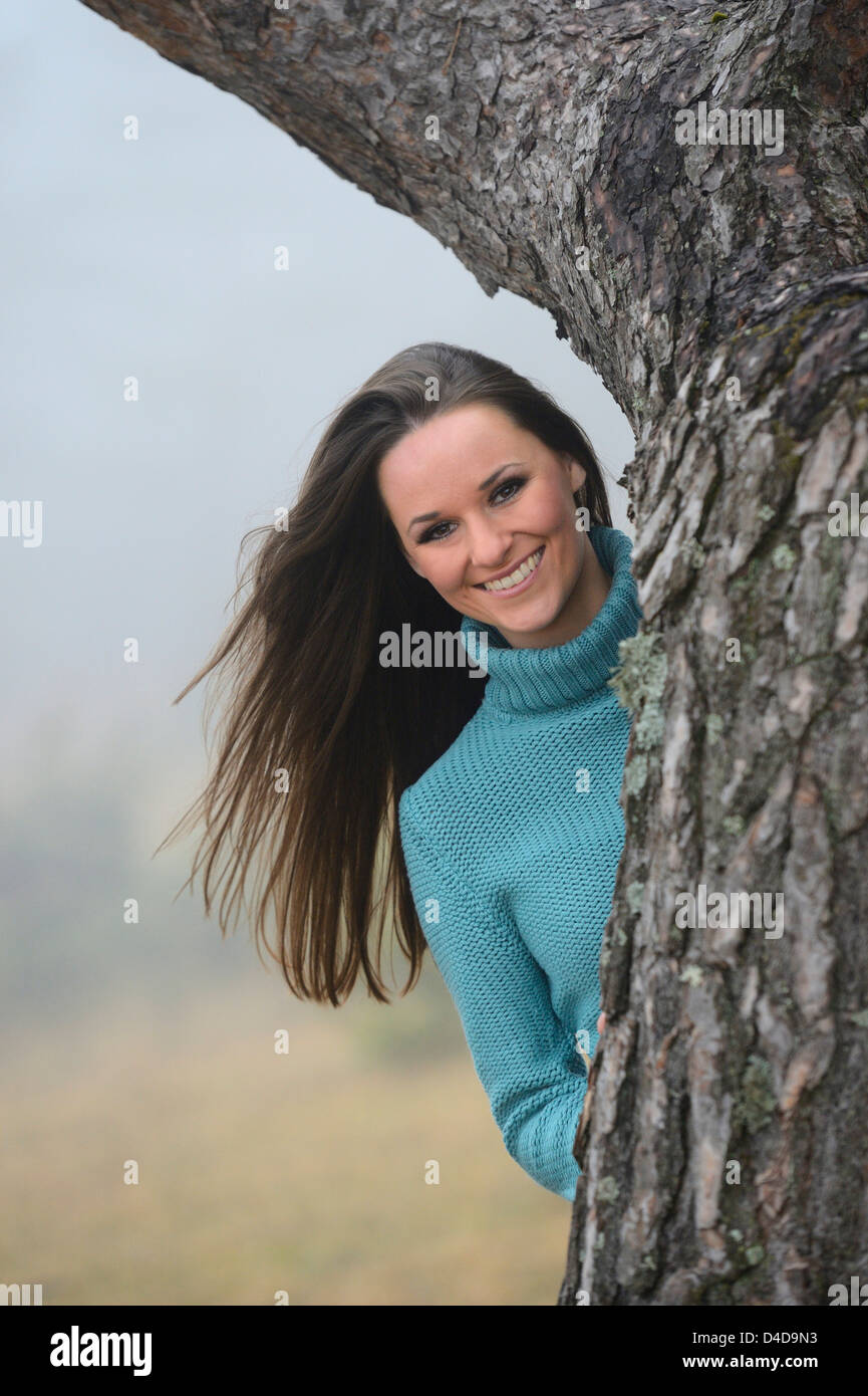 Jeune femme brune au tronc de l'arbre, portrait Banque D'Images