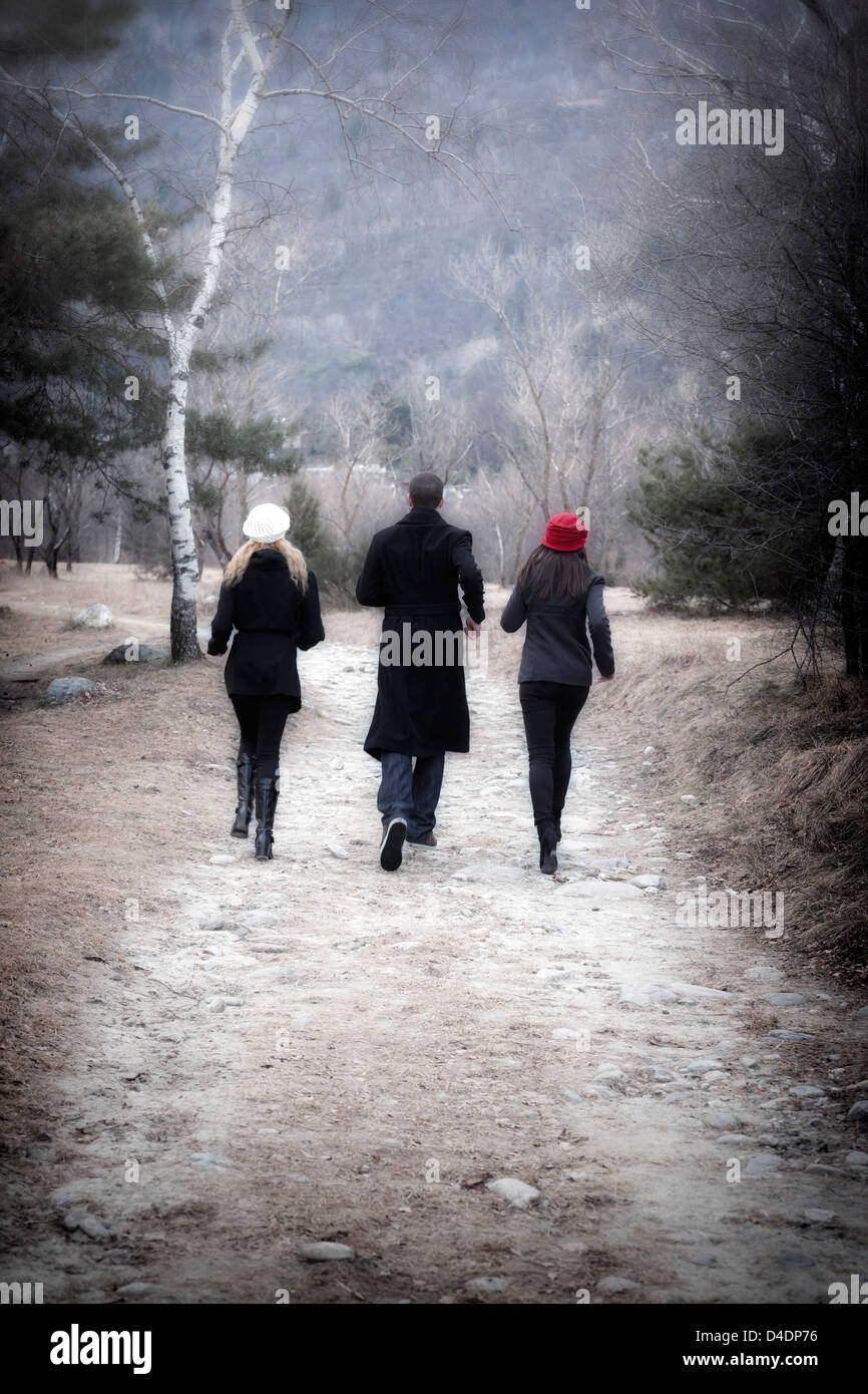 Un homme et deux femmes en marche à travers une forêt Banque D'Images