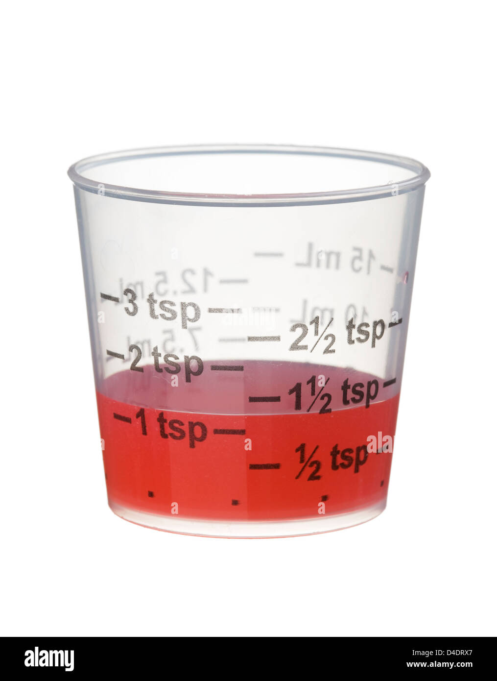 Froid ou du sirop contre la toux médecine dans une tasse de mesure isolé sur fond blanc Banque D'Images